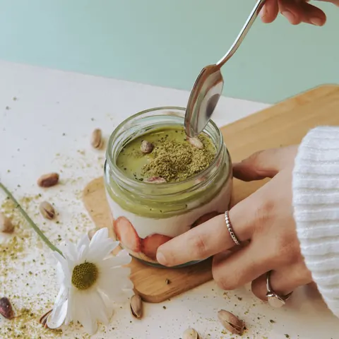 A pistachio mahalabia cup with a spoon
