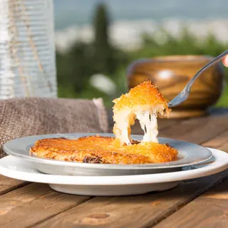 A fork lifting cheese kunafa with stretching cheese