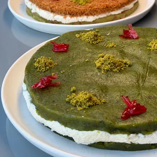 Pistachio kunafa cakes layered with cream on white plates
