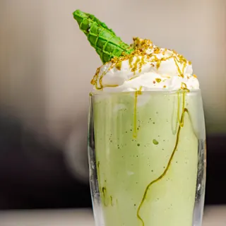 A pistachio milkshake topped with whipped cream