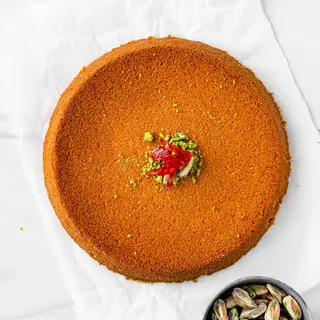 A whole round kunafa seen from above with pistachios
