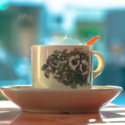 Steaming kopi in a floral kopitiam cup on a saucer
