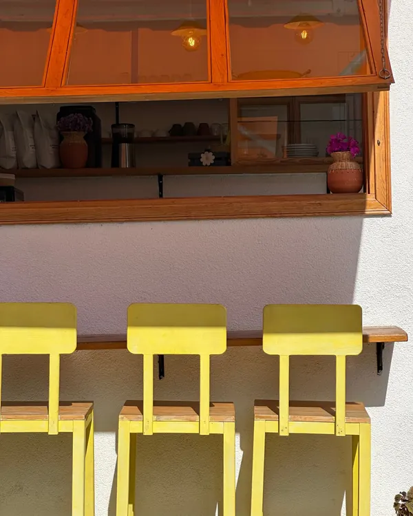 Yellow stools lined up under the café’s open window counter